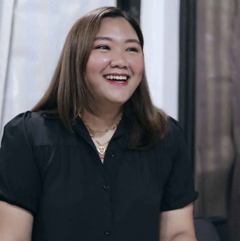 Ivy Constantino smiling in a black blouse